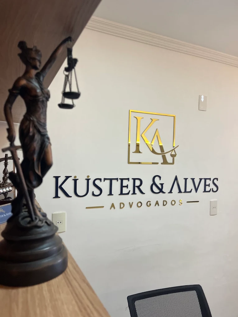 Logo do escritório na parede da recepção com estátua da Justiça